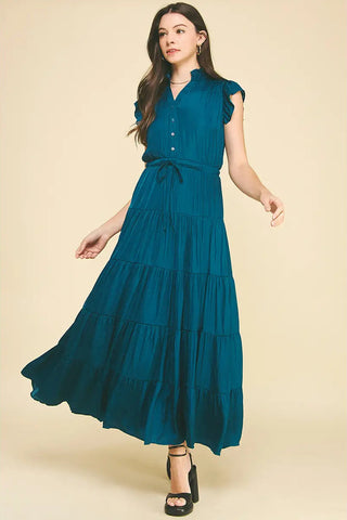 Woman wearing a teal dress on a beige background