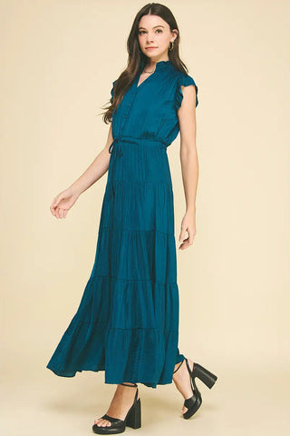 Woman wearing a teal dress on a beige background
