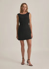 Woman wearing a black dress against a plain background